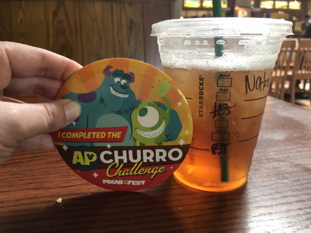Comparing the size of the Disneyland Annual Passholder Churro Challenge prize button to a Starbucks Grande Ice Tea