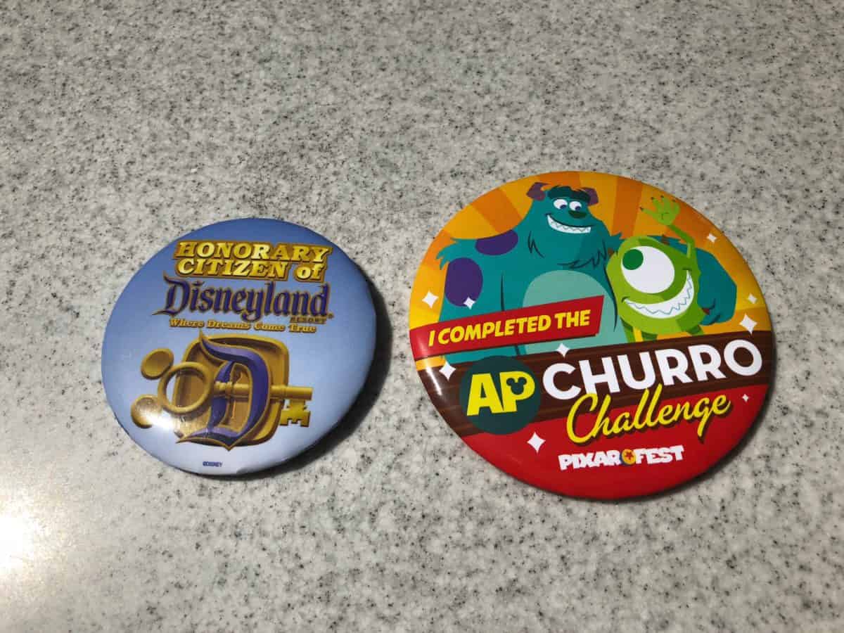 Comparing the size of the Disneyland Annual Passholder Churro Challenge prize button to a standard Disneyland button