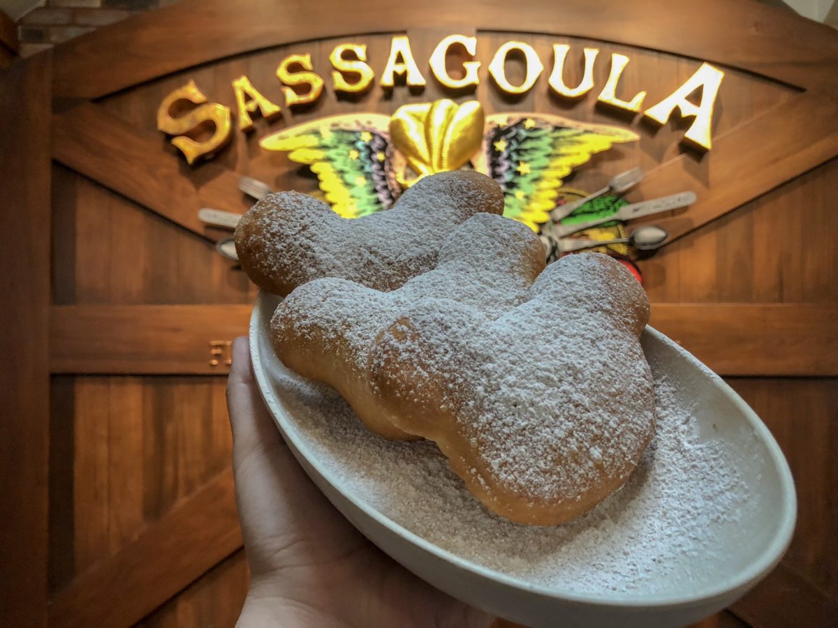Pumpkin spice beignets in front of Sassagoula sign