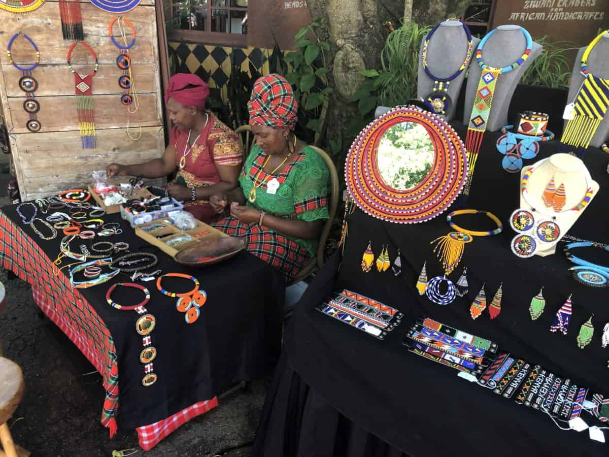 2 women beading necklaces in Africa