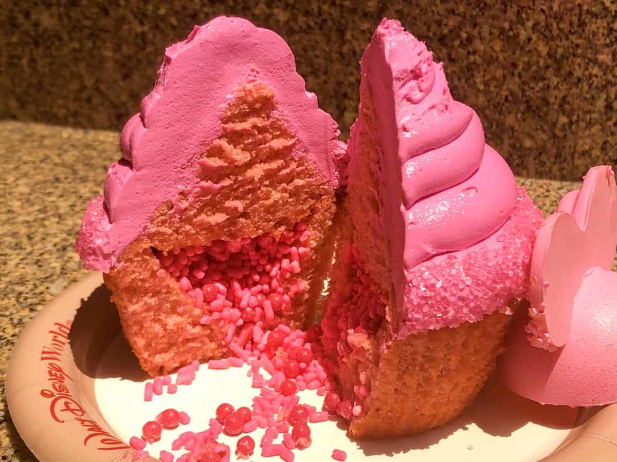 Strawberry cupcake with bright pink vanilla frosting and filled with glittering pink sprinkles and crispy pearls