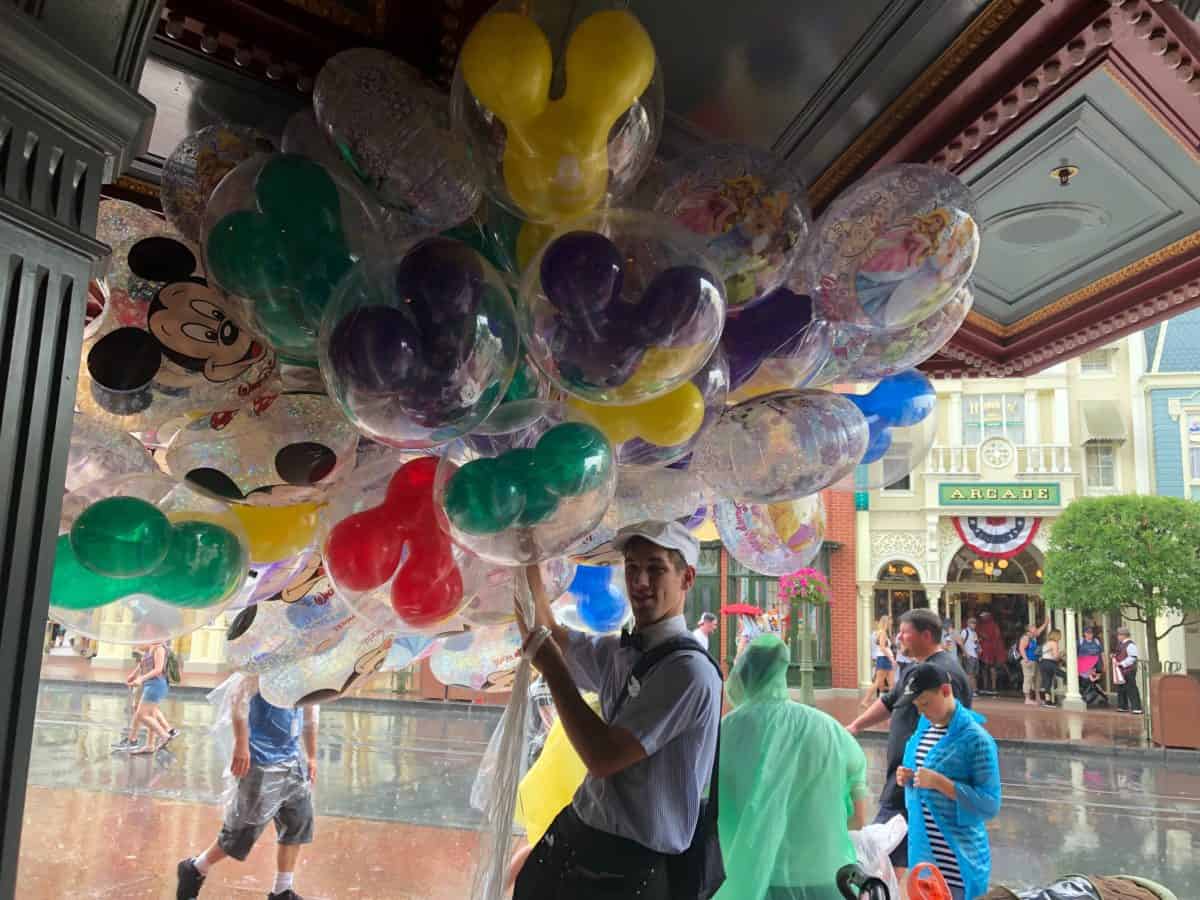balloon holder hiding from the rain under an awning