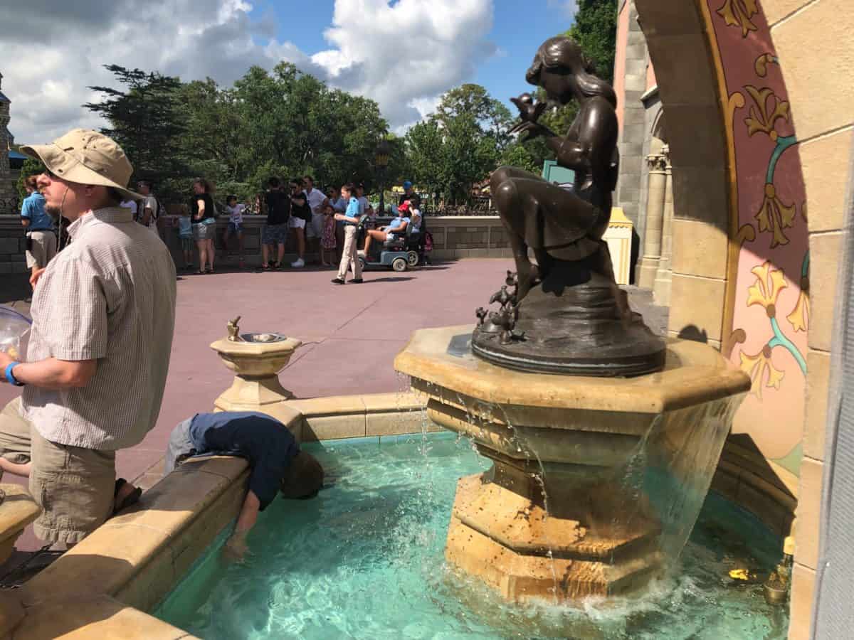 Kid sticking his face in the fountain