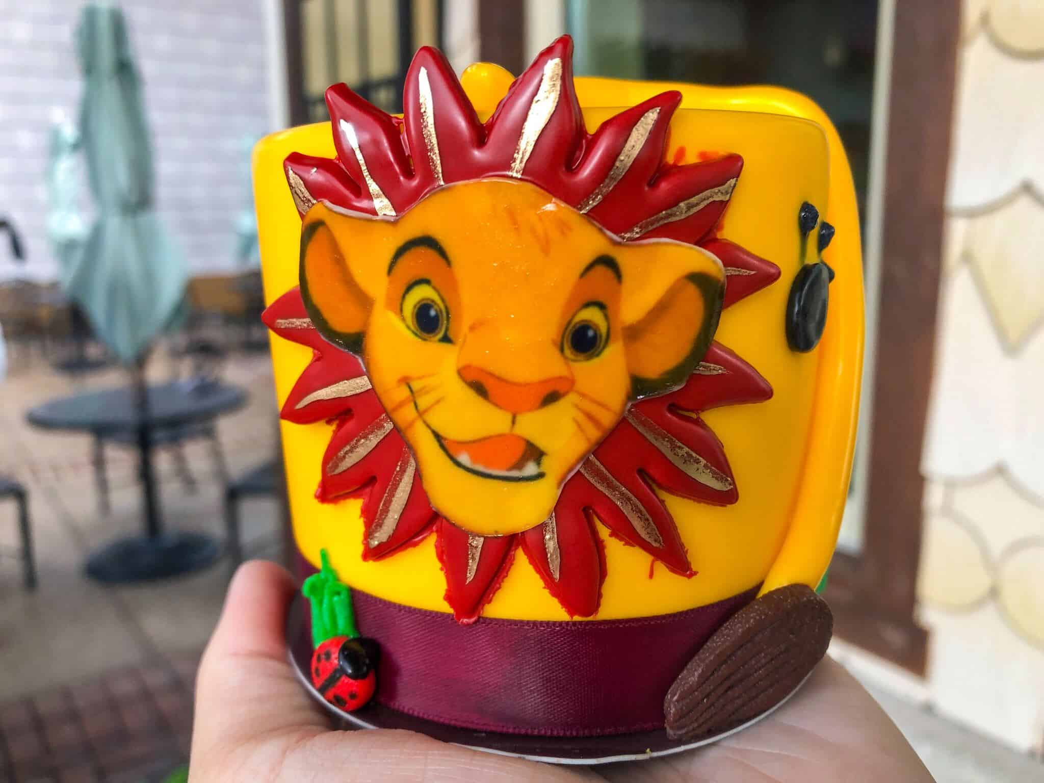 Yellow cake with Simba face, red leaves, fondant tail and paw prints