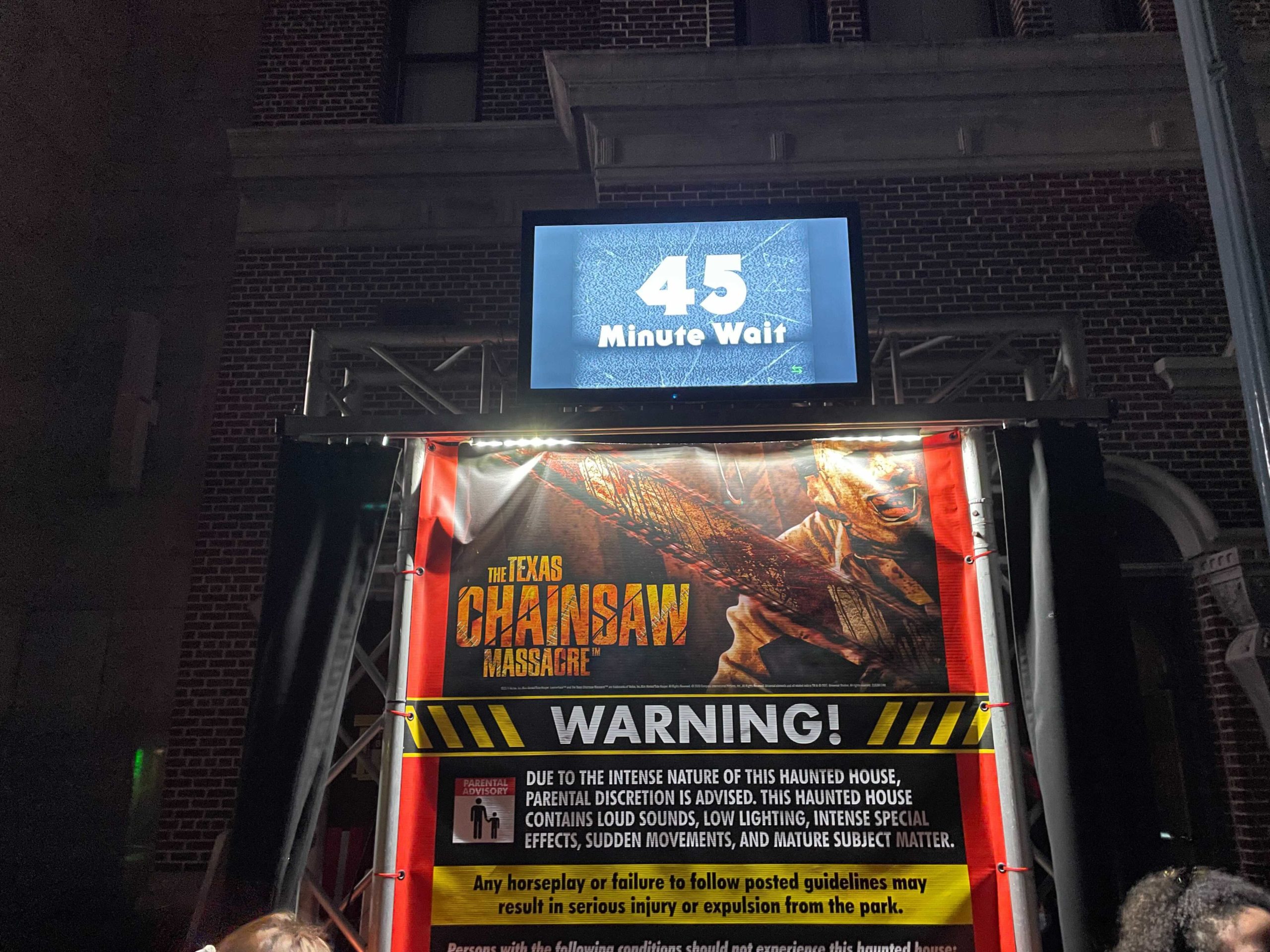 The Texas Chainsaw Massacre Halloween Horror Nights house sign with 45 minute standby wait time