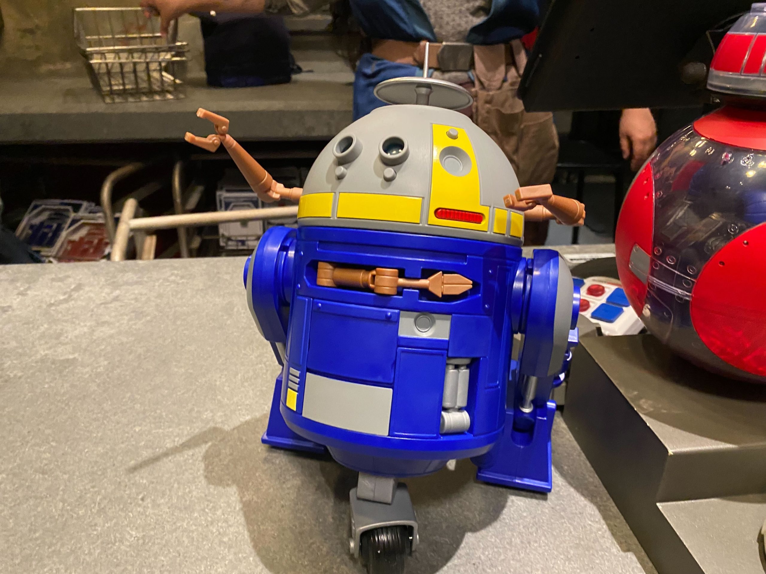 Blue, gray, and yellow C-Series Star Wars Droid with arms sticking out of its domed head