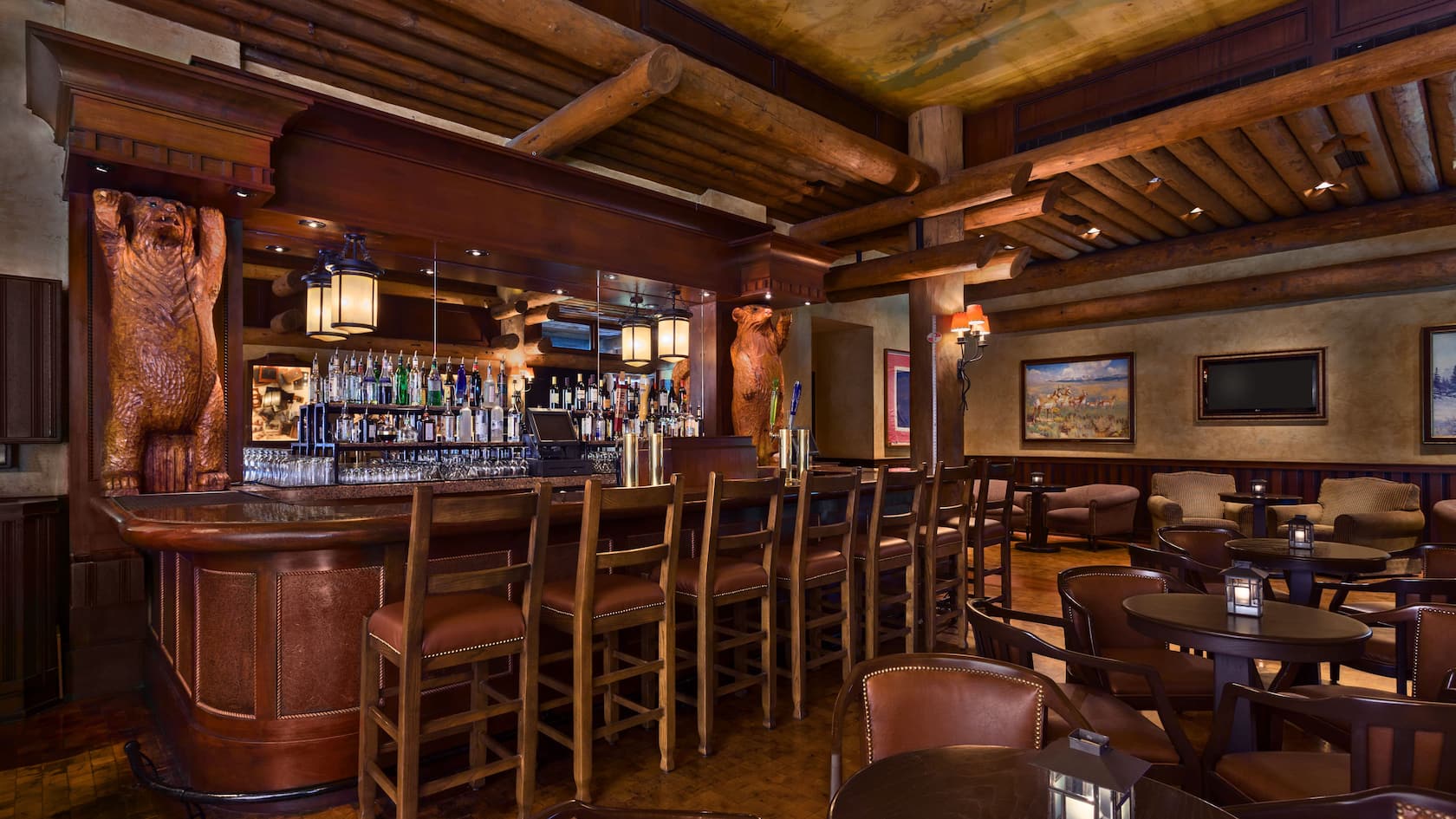 A rustic bar interior reminiscent of a Wilderness Lodge, featuring wooden bar stools, bear carvings, and an array of liquor bottles. Wooden beams adorn the ceiling, similar to Disney World's Territory Lounge, with tables and brown chairs completing the inviting seating area.