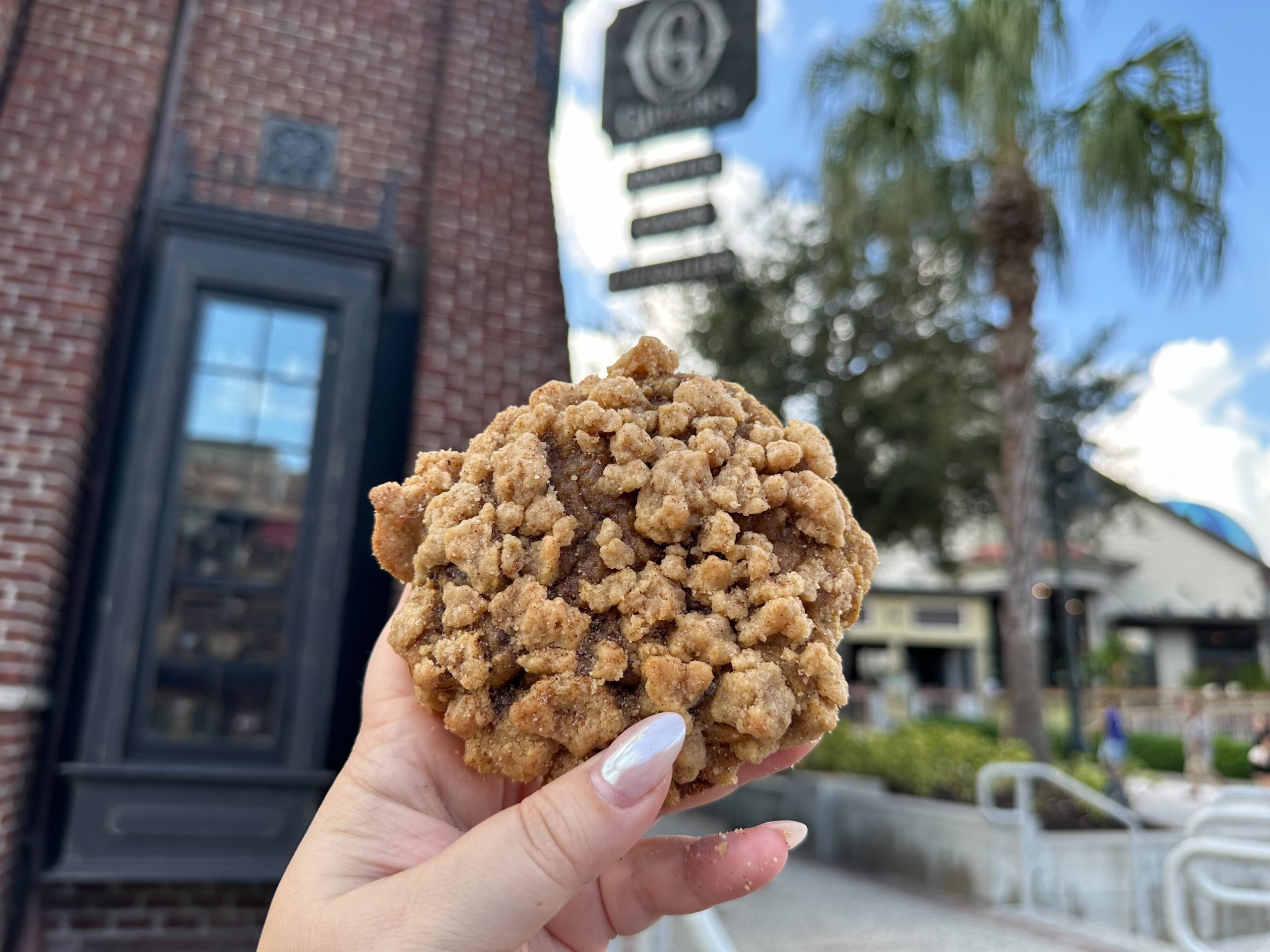 Cookie held in front of Disney Springs Gideon's Bakehouse sign