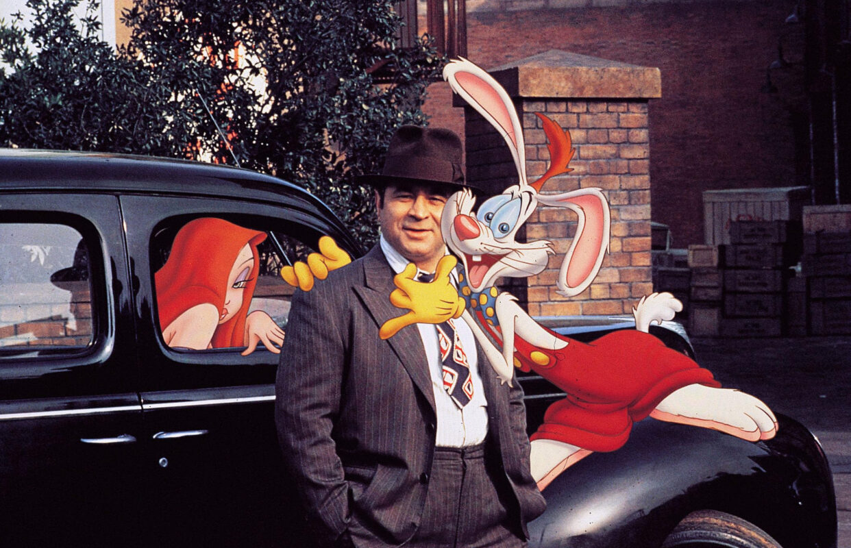 A man in a suit and hat stands next to a cartoon rabbit reminiscent of "Who Framed Roger Rabbit," alongside a woman character inside a vintage car, creating an enchanting blend of live-action and animation.