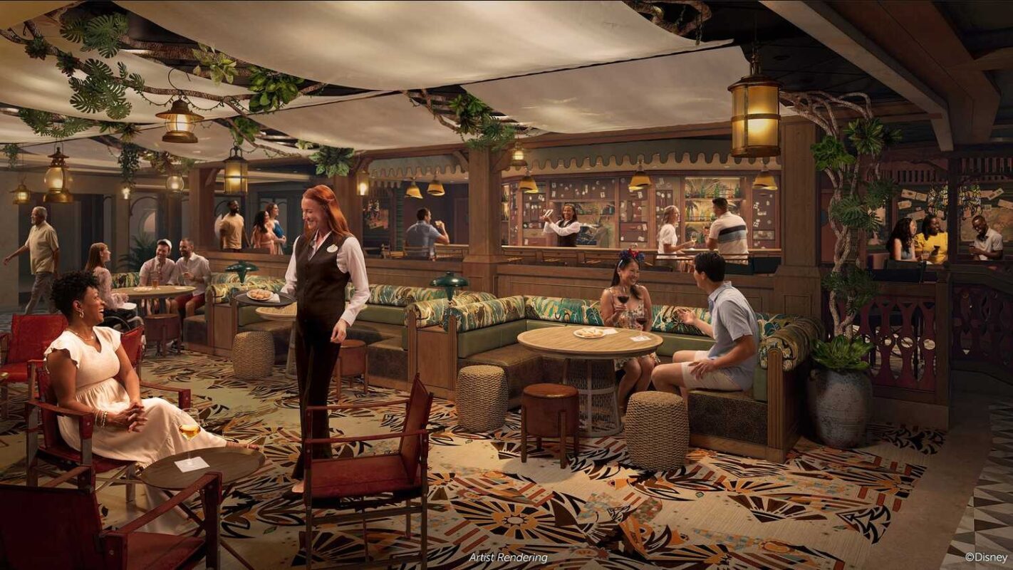 People are seated and talking in a cozy, warmly-lit tropical-themed bar with wooden decor and a leafy canopy above. A waitress, dressed like she stepped out of a Disney treasure, is serving guests amidst a relaxed and inviting atmosphere.