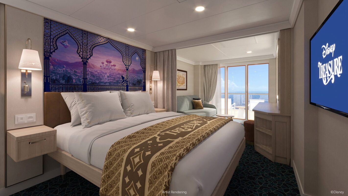 A well-lit stateroom on the Disney Treasure featuring a large bed with white linens, a decorative headboard, a sofa, a TV displaying "Disney Treasure," and a balcony with a stunning ocean view.