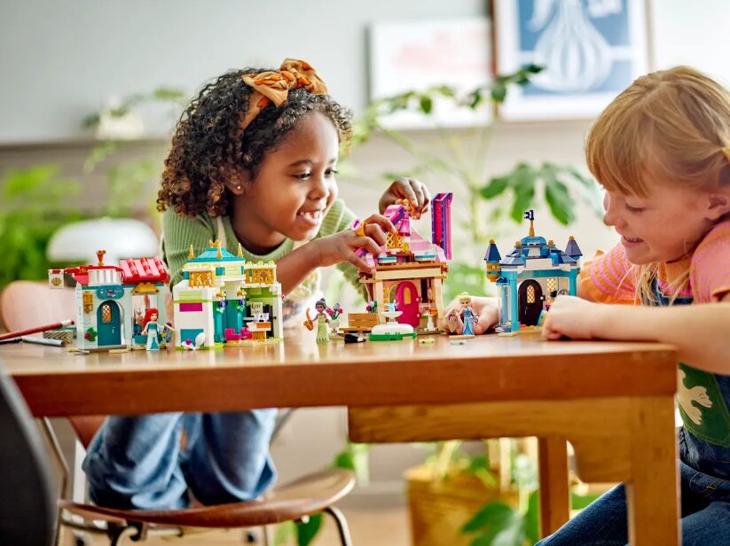 Two children play with the Disney Princess Market Adventure LEGO set.