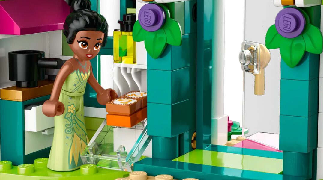 A LEGO mini doll of Princess Tiana pulls LEGO beignets out of the oven.