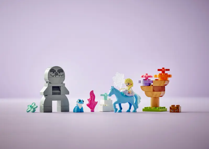 A look at all of the included pieces in the LEGO Duplo Elsa and Bruni in the Enchanted Forest set, which includes a rock creature, Bruni, a pink flame, Nokk the water spirit, an Elsa figure, a tree, and more.