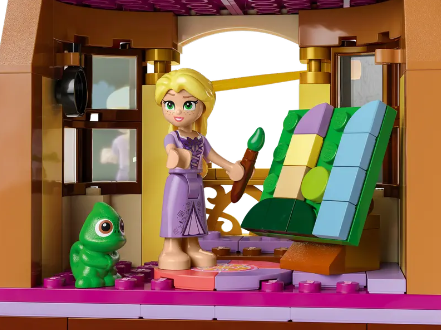A LEGO Disney mini doll of Rapunzel from "Tangled" works on her latest masterpiece as a LEGO figure of Pascal the chameleon looks on.