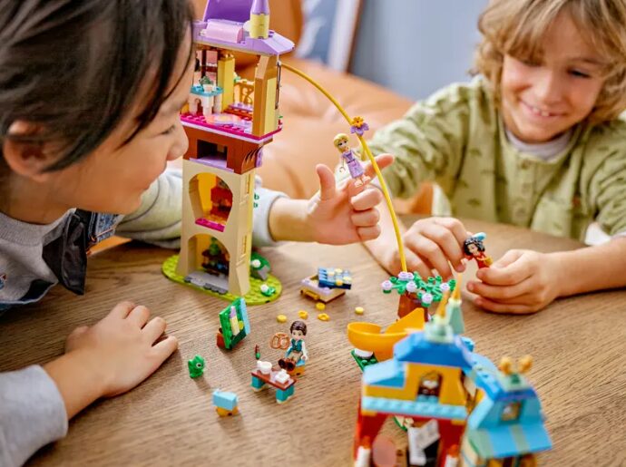 Two children play with the LEGO Rapunzel's Tower & The Snuggly Duckling set.