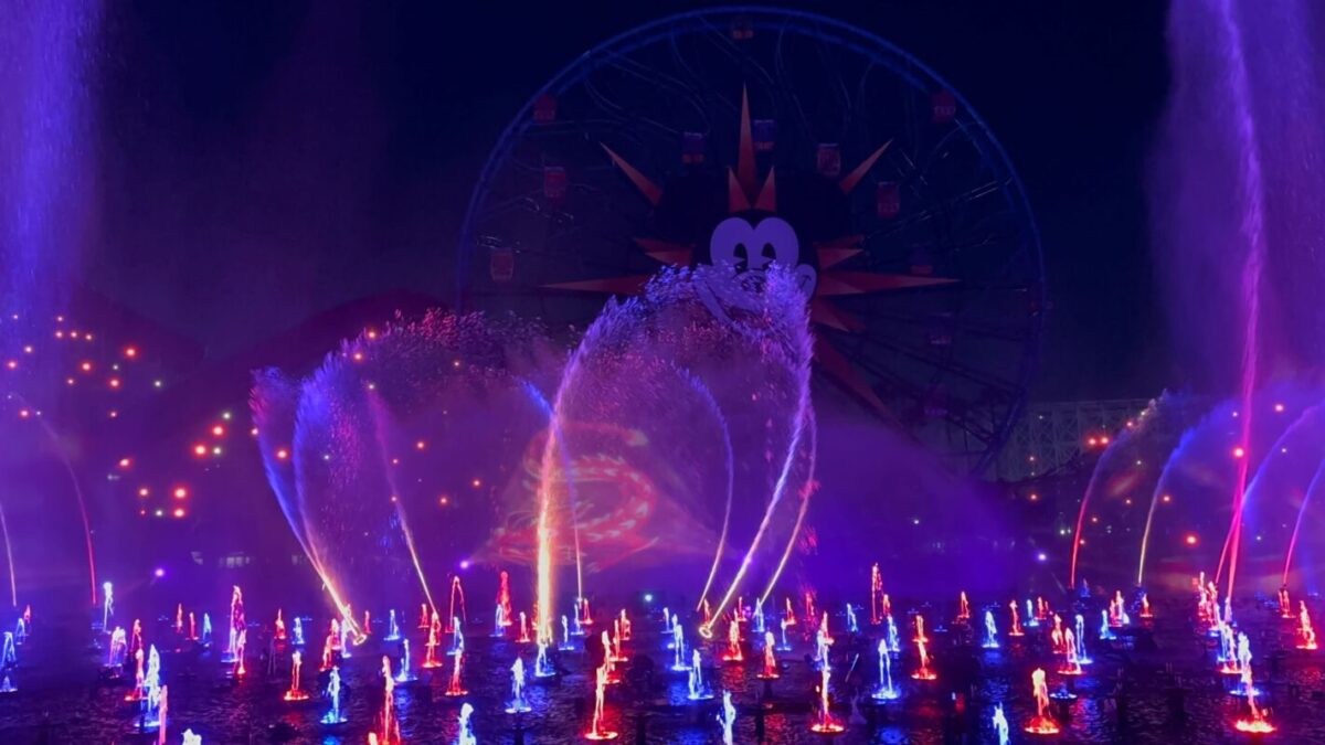 Mushu appears as water fountains light up blue and red around him.