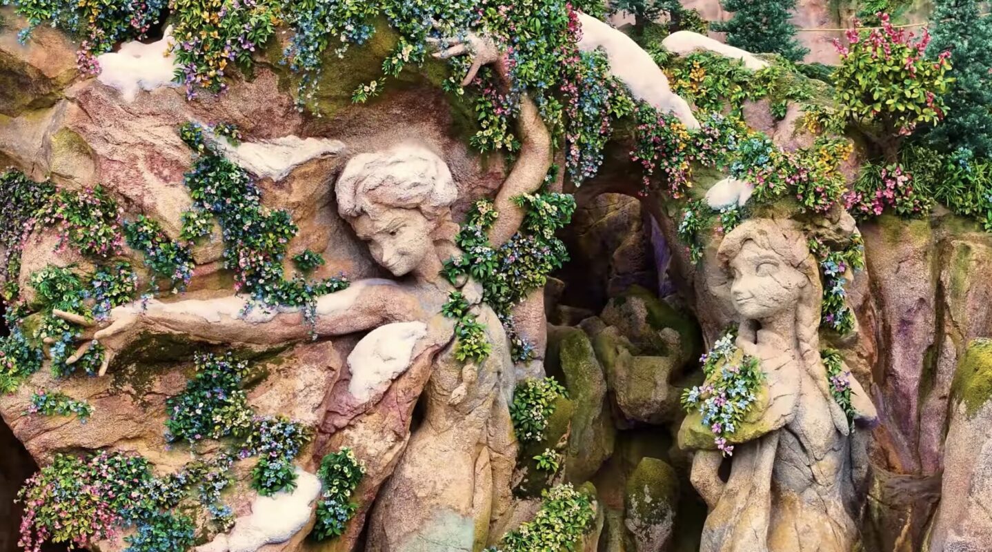 Anna and Elsa sculptures in rock covered in vines