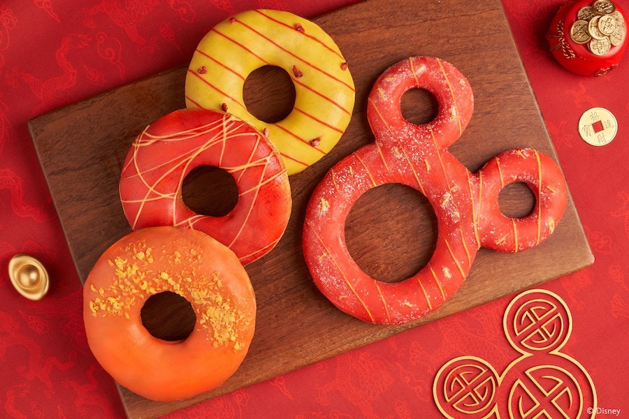 A collection of four New Year Donuts. One is shaped like a Mickey head.
