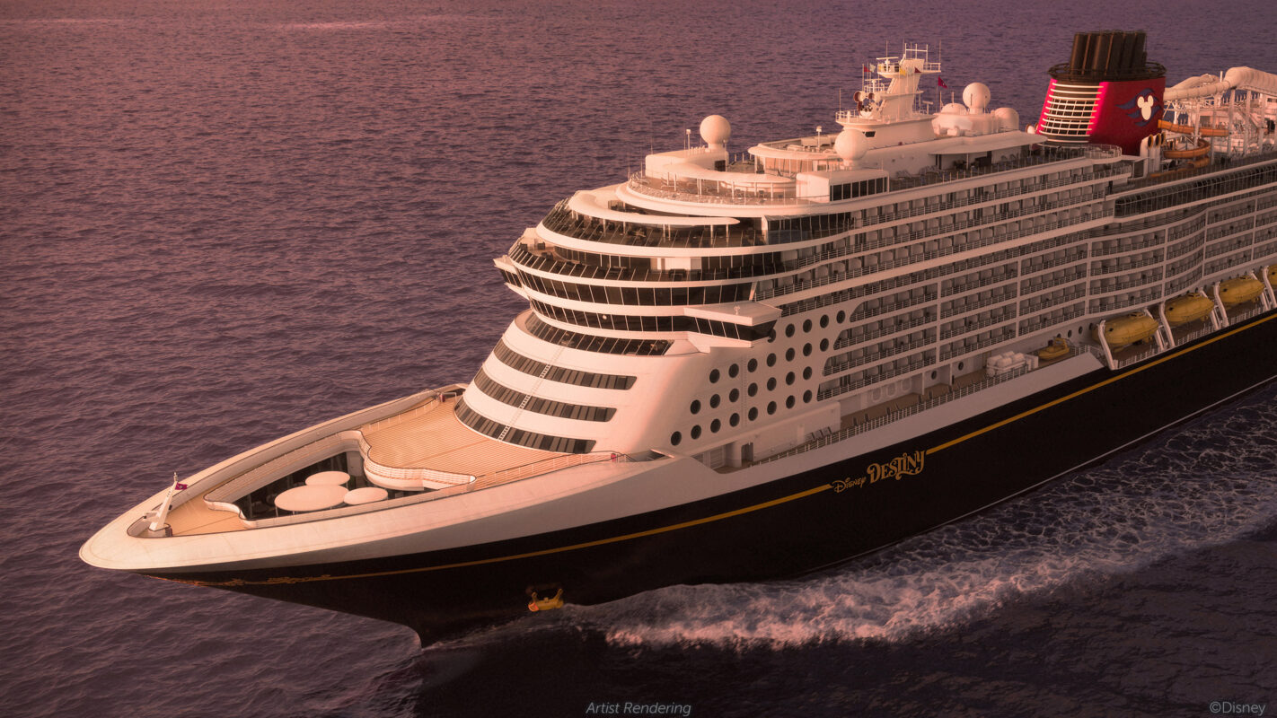 A large Disney Cruise Line ship sails on calm waters at sunset, featuring a black hull, multiple decks, and enchanting Disney-themed decorations.