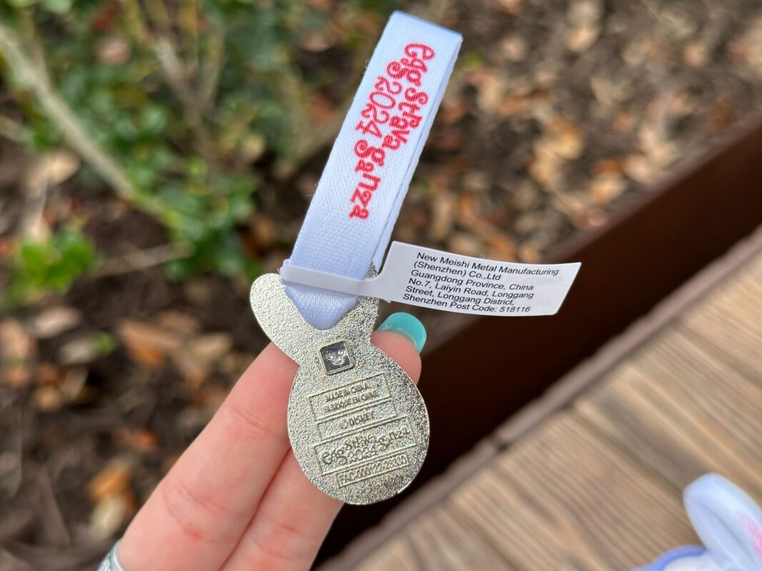 A reporter's hand holds the Judy Hopps prize charm for Eggstravaganza 2024, specifically showing the back.