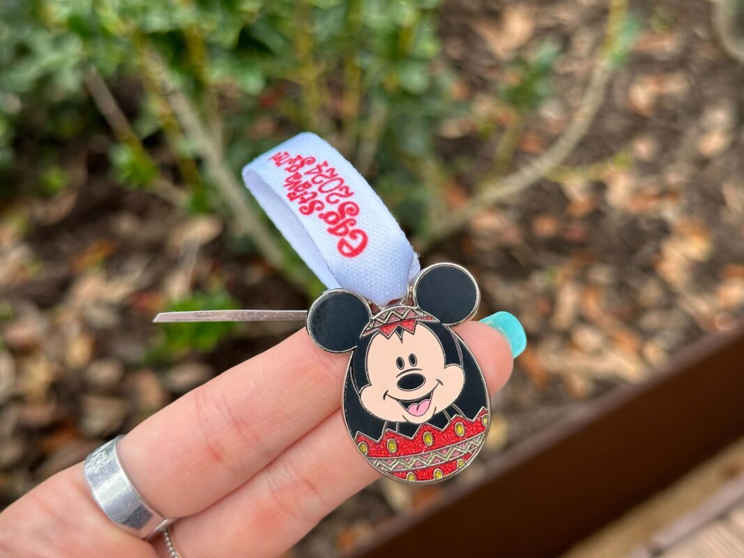 A reporter's hand holds the Mickey Mouse prize charm for Eggstravaganza 2024.