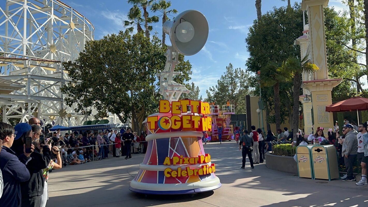 A giant Luxo Jr. lamp on a small float with "Better Together a Pixar Pals Celebration" in yellow letters