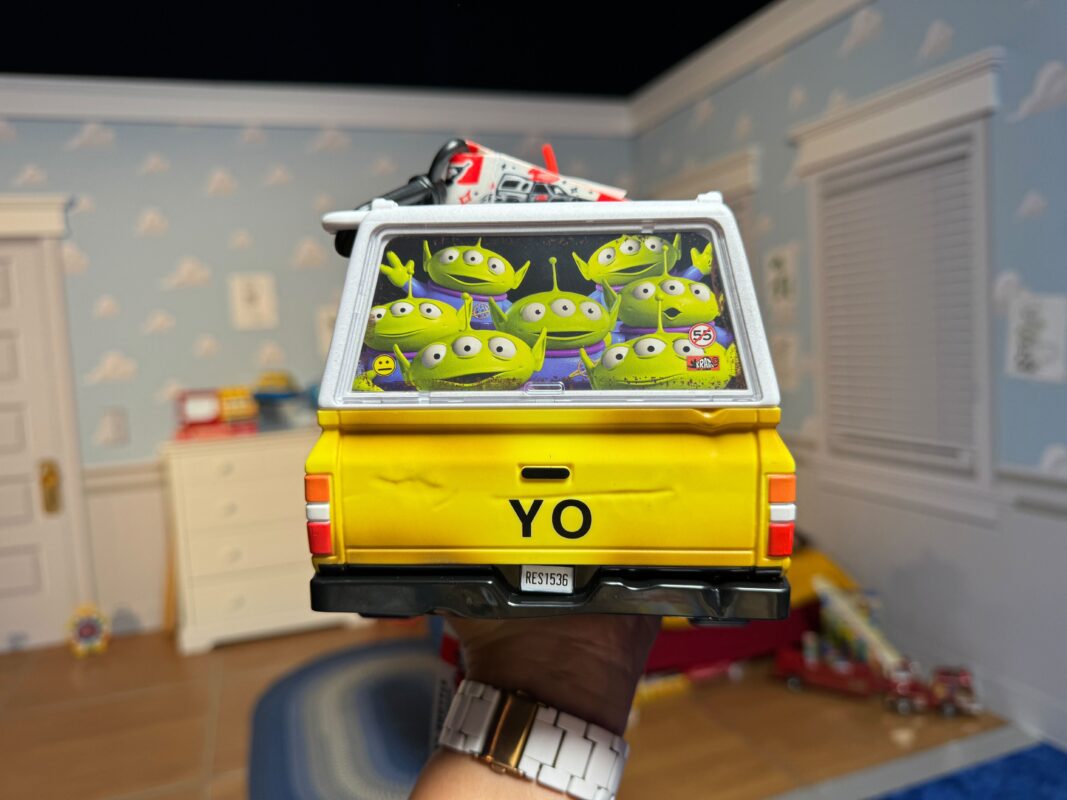 A reporter's hand showing the back of the Pizza Planet Truck popcorn bucket.