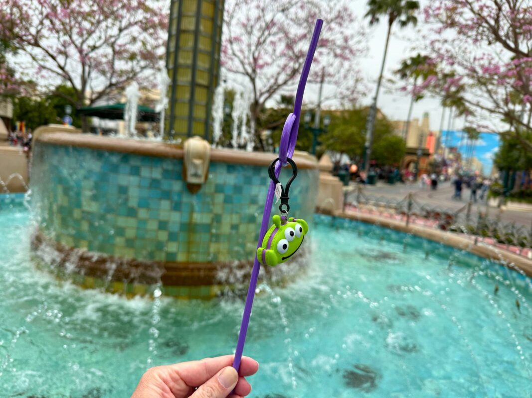 A reporter's hand holding a purple straw with the Alien Macaron straw clip attached.