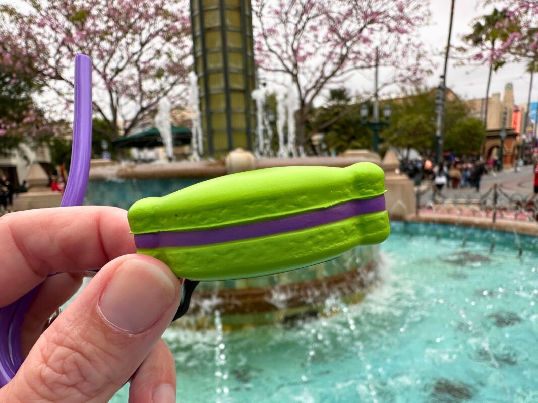A reporter's hand showing the side of the Alien Macaron Straw Clip.