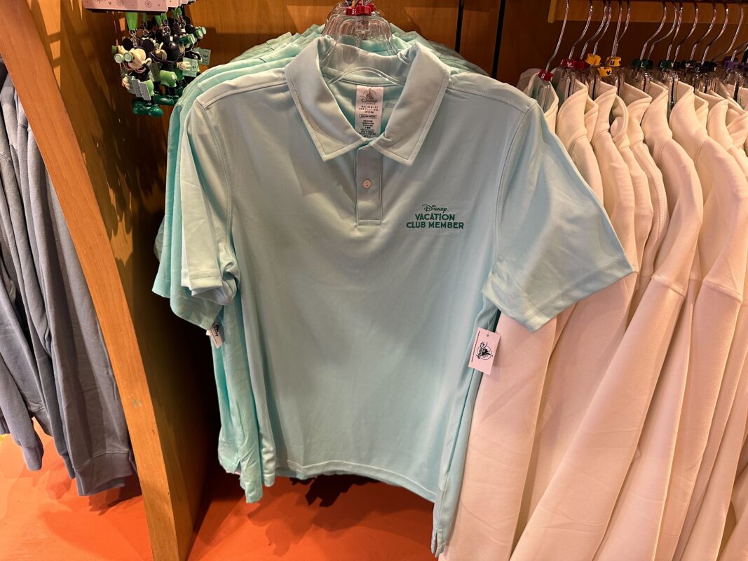 DVC polo shirt hanging on a merchandise display clothing rack.