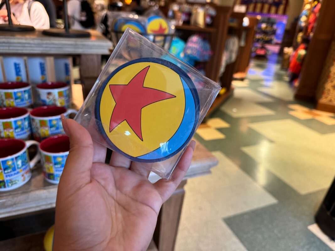 A reporter's hand holding a Pixar silicone coaster set.