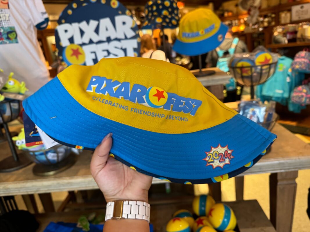 A reporter's hand holding a Pixar Fest bucket hat.