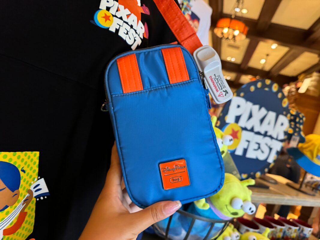 A reporter's hand showing the back of the Pixar Fest Lug crossbody bag.