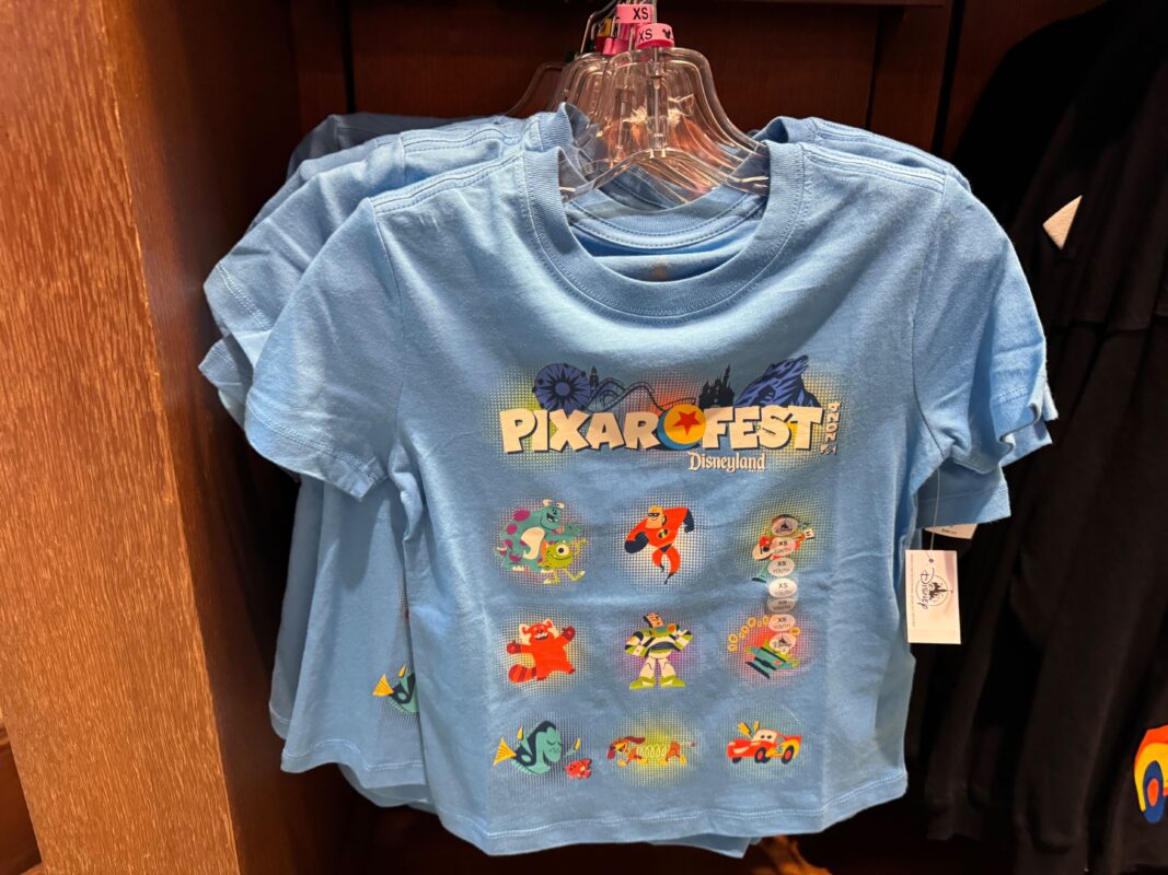 A blue youth Pixar Fest T-shirt hanging on a rack.