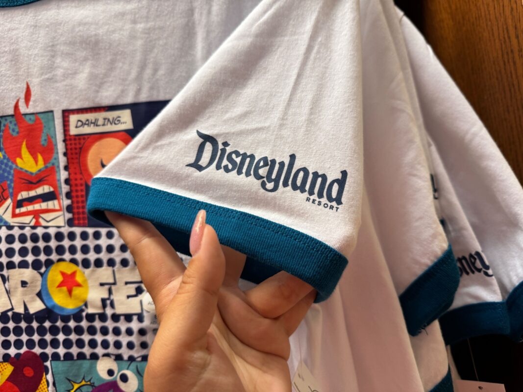 A reporter's hand showing the Disneyland Resort logo on the sleeve of the ringer T-shirt.