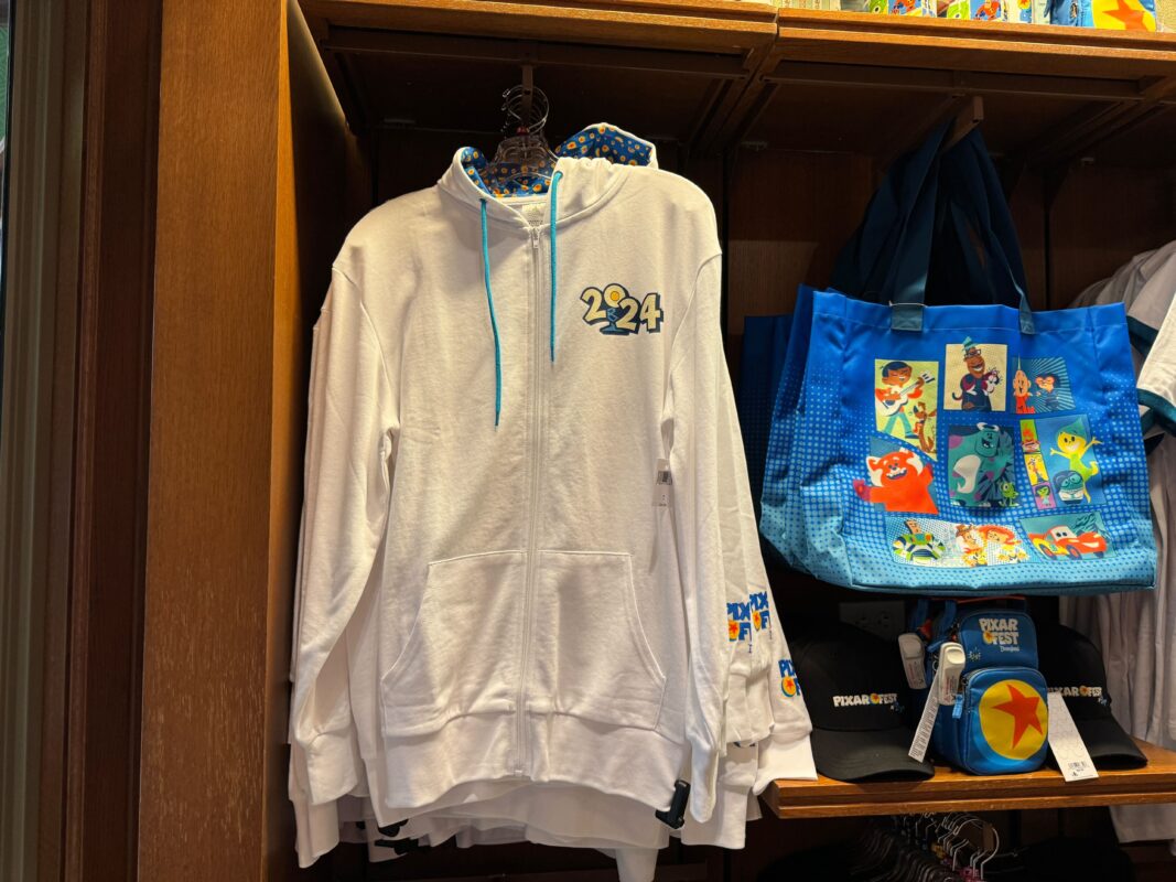 The front of a Pixar Fest hoodie hanging on a rack.