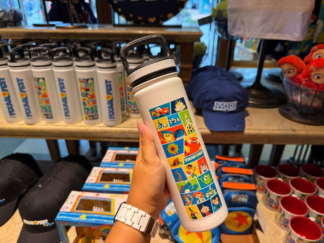 A reporter's hand showing the other side of the Pixar Fest water bottle.