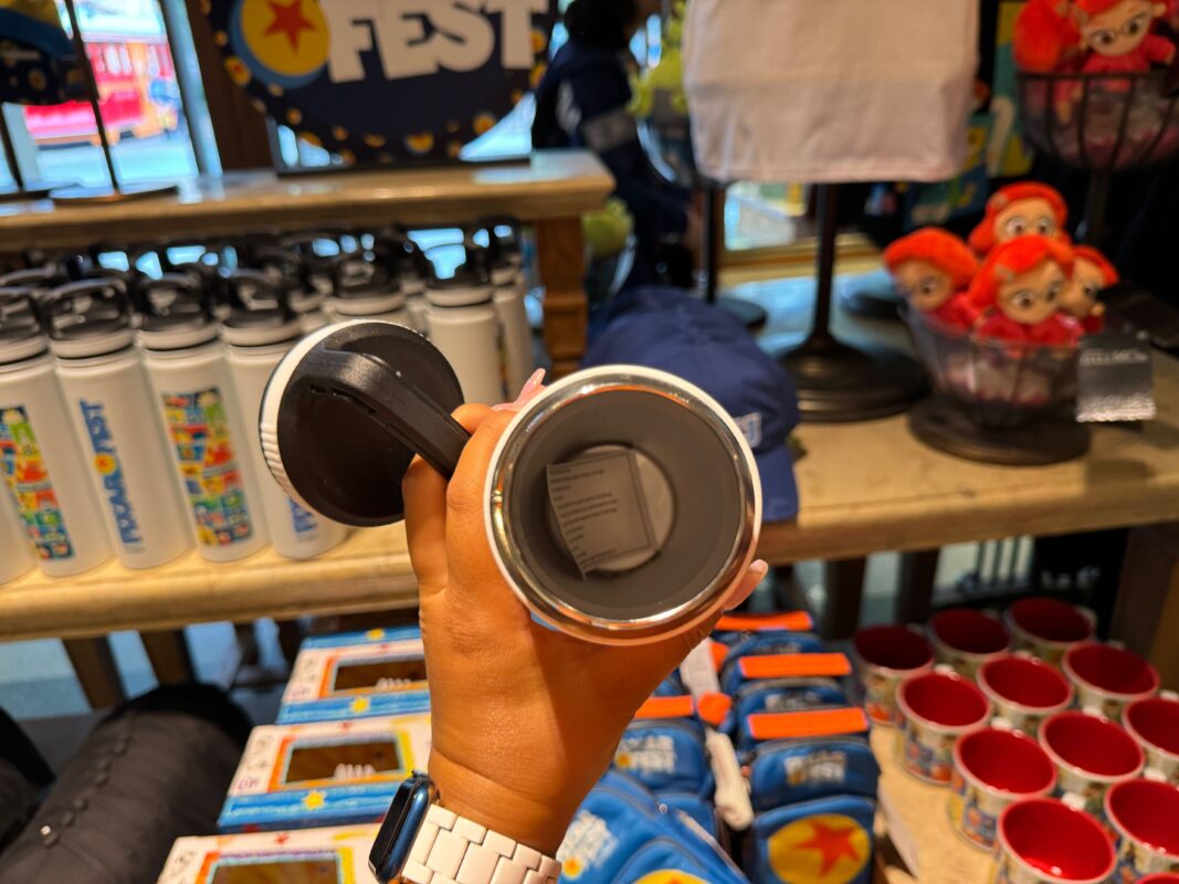 A reporter's hand showing the inside of the Pixar Fest water bottle.