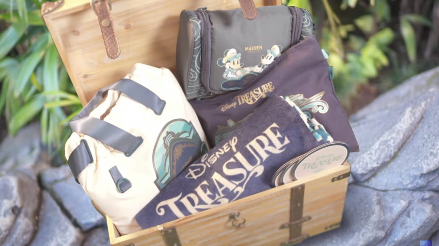 A wooden chest full of Castaway Club Disney Treasure gifts: bags, a towel, and pucks.