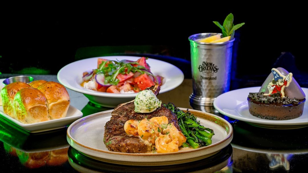 Plates of salad, steak, bread, and a "Fantasmic"-inspired dessert