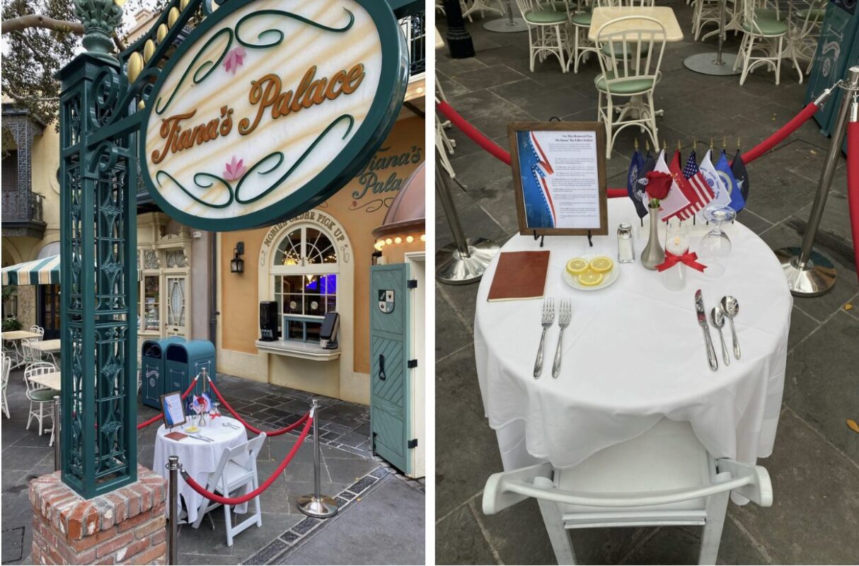 A small outdoor table set for one, positioned in front of Tiana's Palace. The table features utensils, lemon slices, and small American, French, and military flags within a roped-off area.