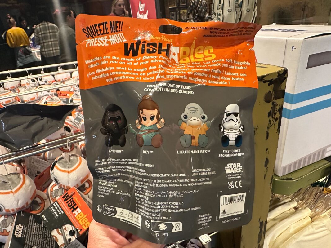 A hand holding a package of "Rise of the Resistance" Star Wars wishables collectible plush toys featuring characters like Rey and a First Order stormtrooper in a store.