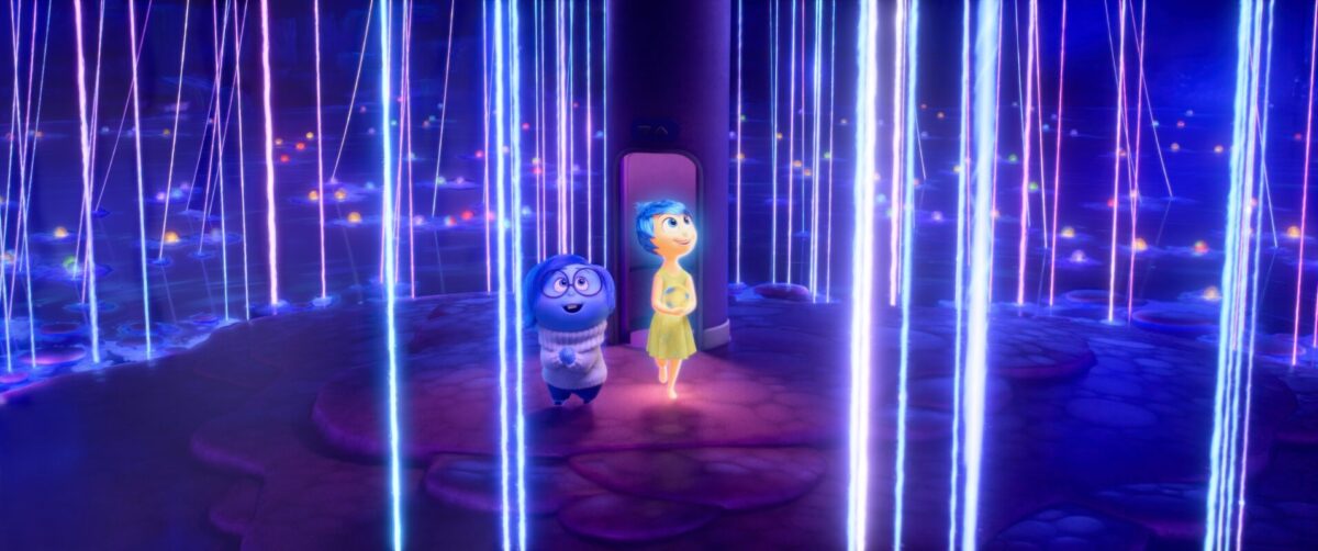 Two animated characters, one blue and one yellow, stand surrounded by glowing vertical lines in a dark, fantastical environment reminiscent of Inside Out 2.