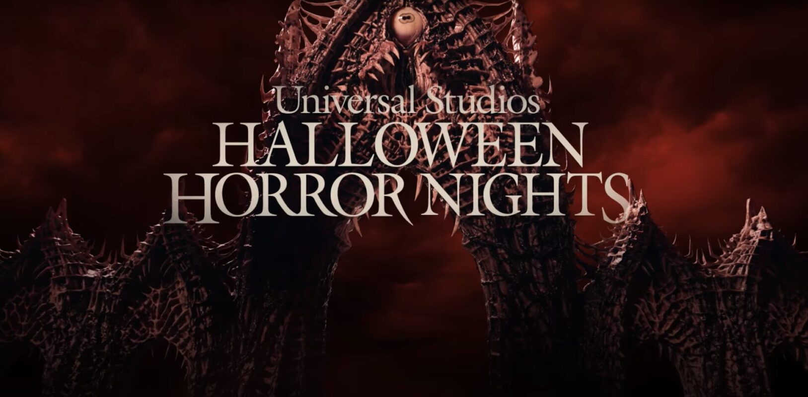 The Universal Studios Halloween Horror Nights 2024 logo is displayed against a background of dark, eerie, and spiky structures set against a crimson and black sky.