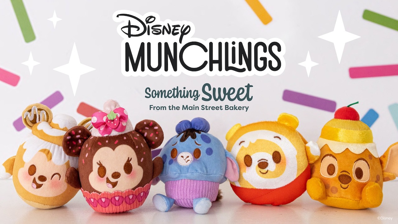 Plush toys of Disney Munchlings characters from the Main Street Bakery are arranged in a row. They each have sweet treat themes and bright colors.