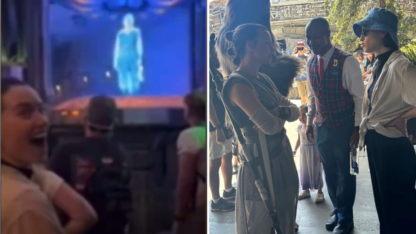 People engaging with a holographic display and chatting with staff in themed attire at a themed park.