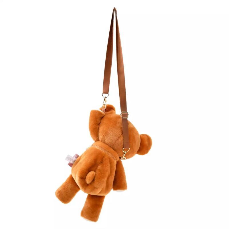 A brown teddy bear-shaped purse with brown shoulder straps, hanging and viewed from behind.