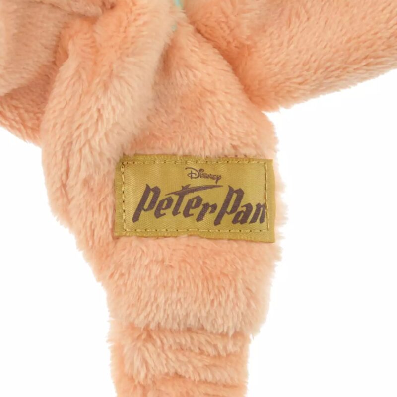 Close-up of a beige plush fabric with a yellow tag labeled "Disney Peter Pan.