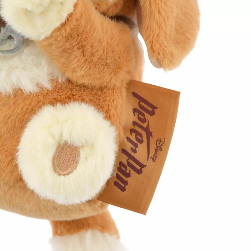 Close-up of a plush toy with a brown and white furry texture. The toy has a label reading "Disney peter pan.